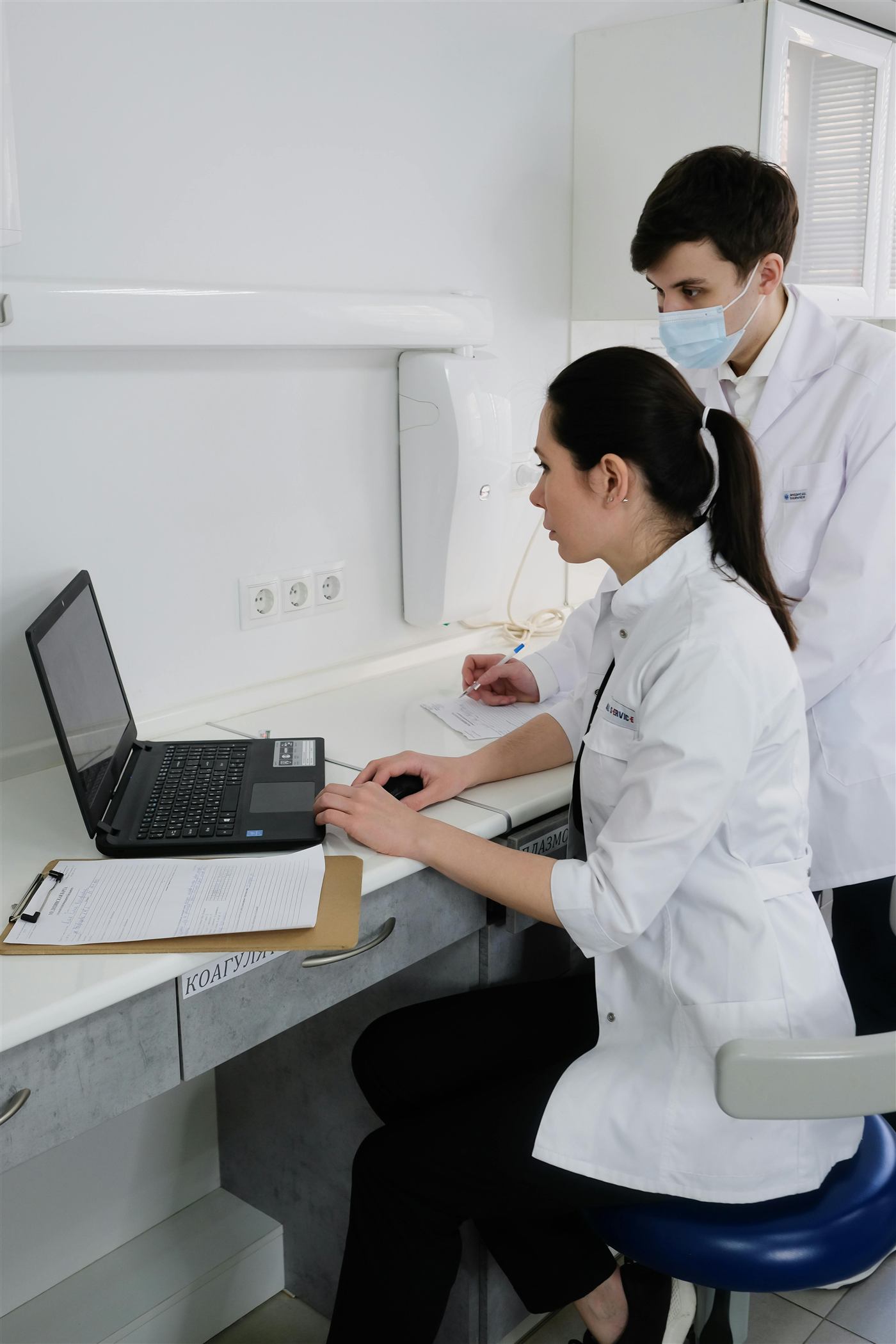 Profissionais de saúde usando laptop em ambiente clínico